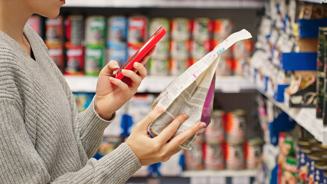 a woman scanning the back of a dog food bag in a store to understand the label
