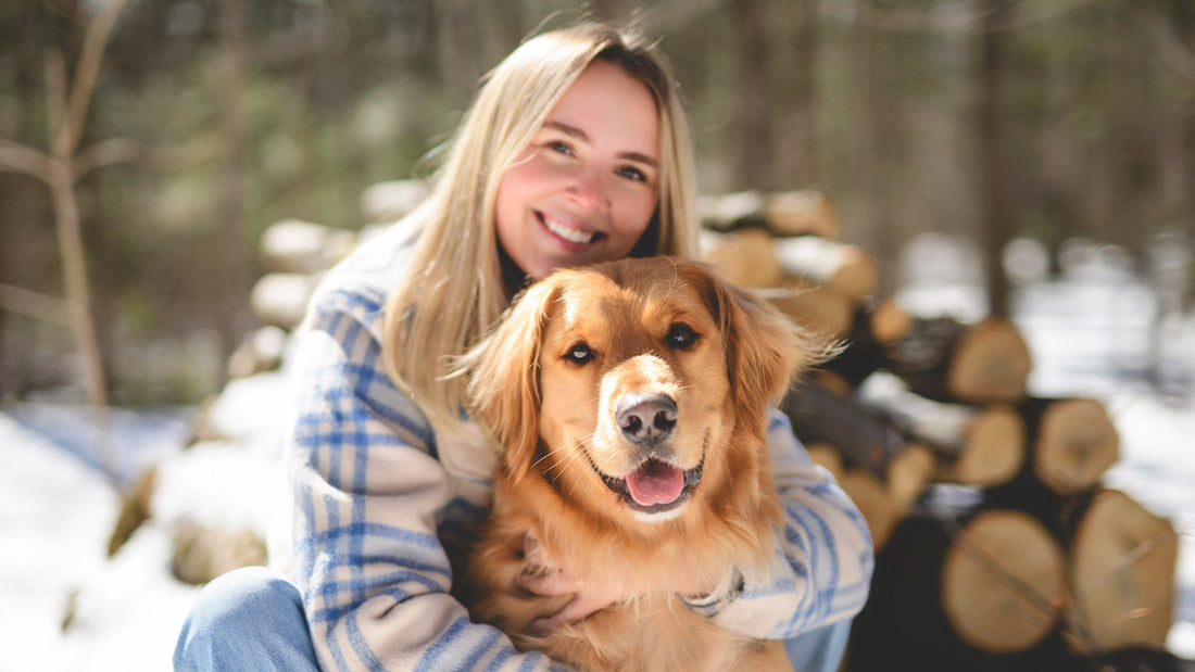  Young woman outside with golden retriever dog.